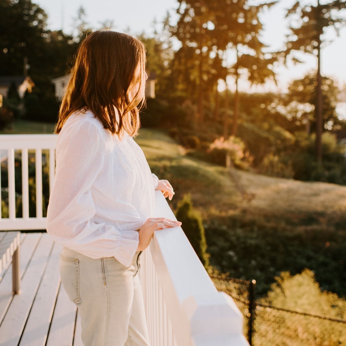 Woman gazing out at the water from her deck while grieving and healing following a miscarriage